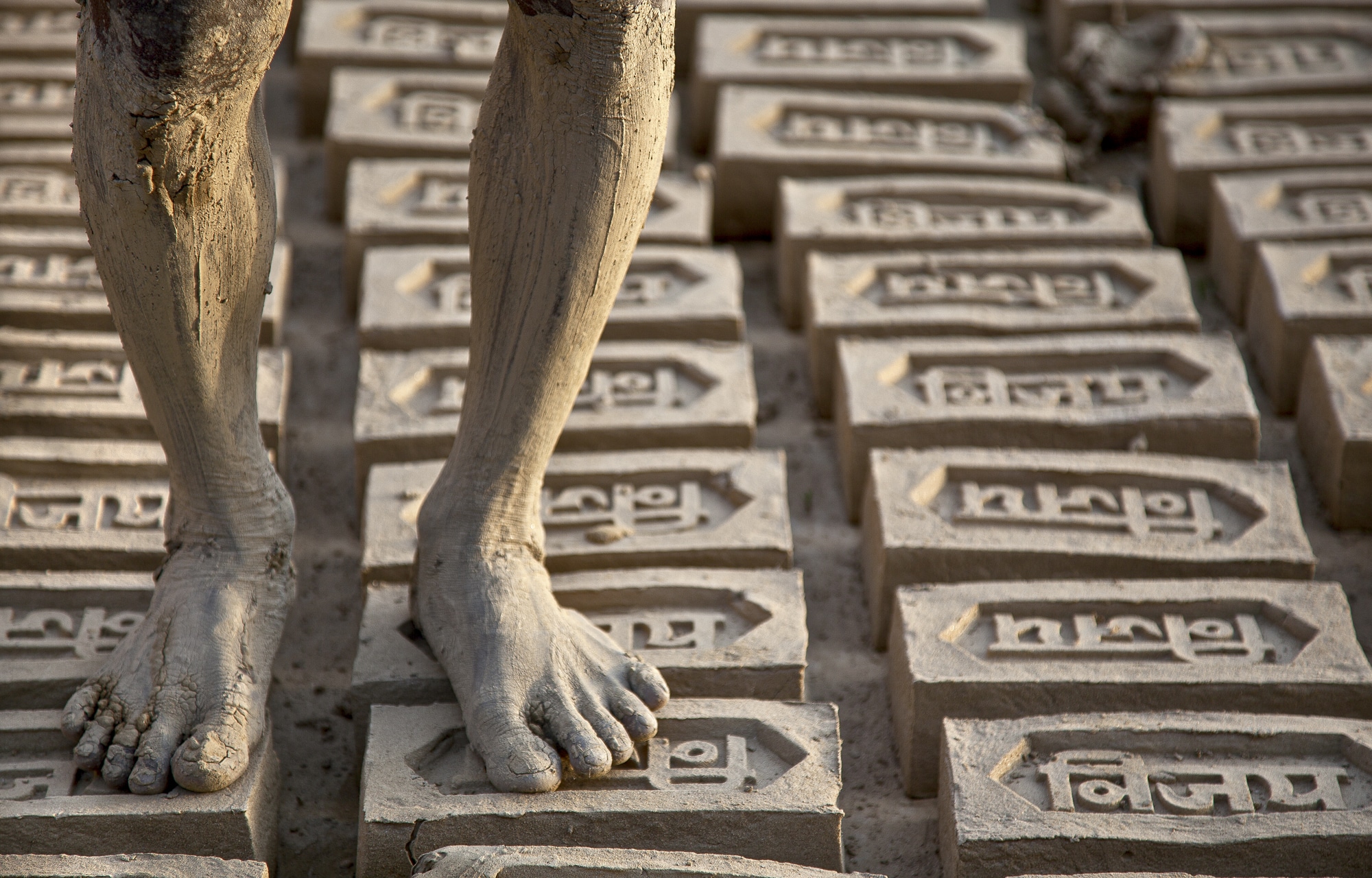 Man standing barefoot on bricks