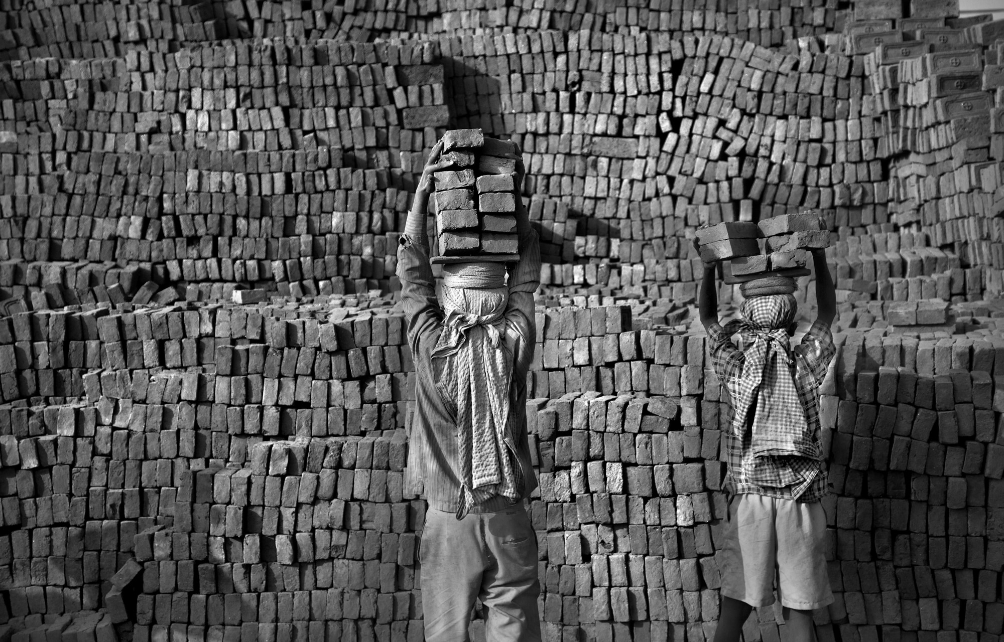 Brothers carrying bricks on their heads in Nepal