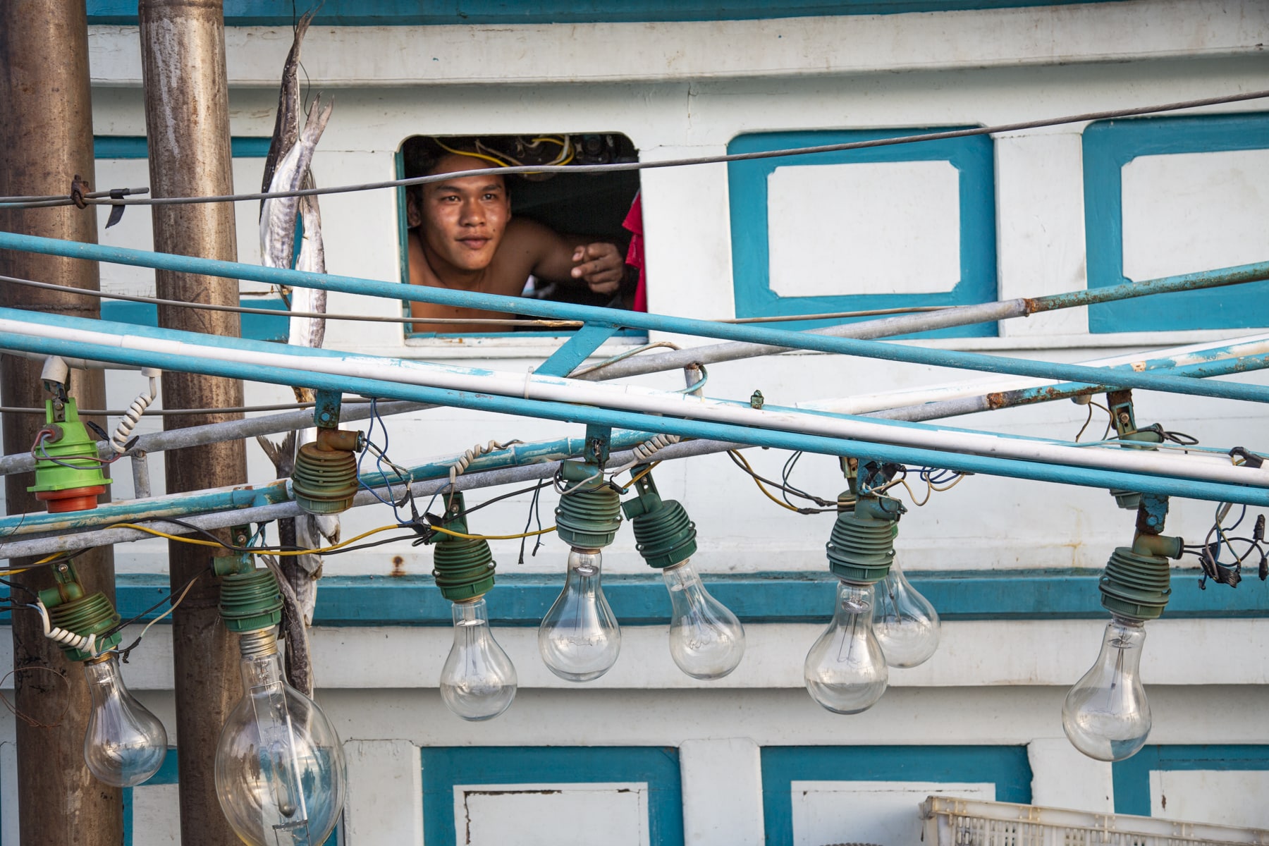 Man peering out the window in a boat in Thailand