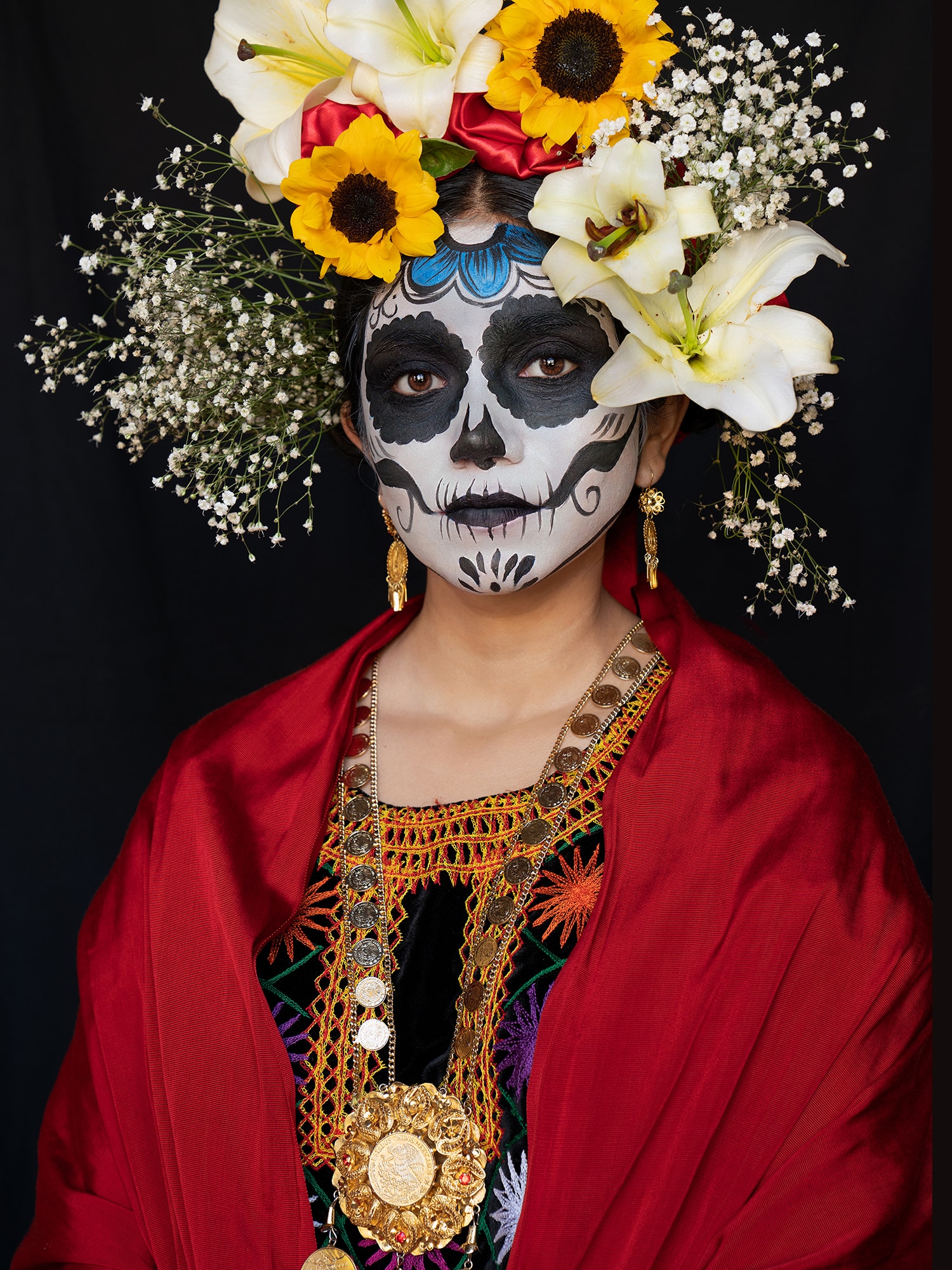 Looking into her eyes and painted face means recognizing those who have passed and honoring the dead. Her headdress of blossoms, the crimson red of her cloak, and the glow of gold earrings and necklace exude warmth, energy, nurturance, durability…eternity. Ancestors.