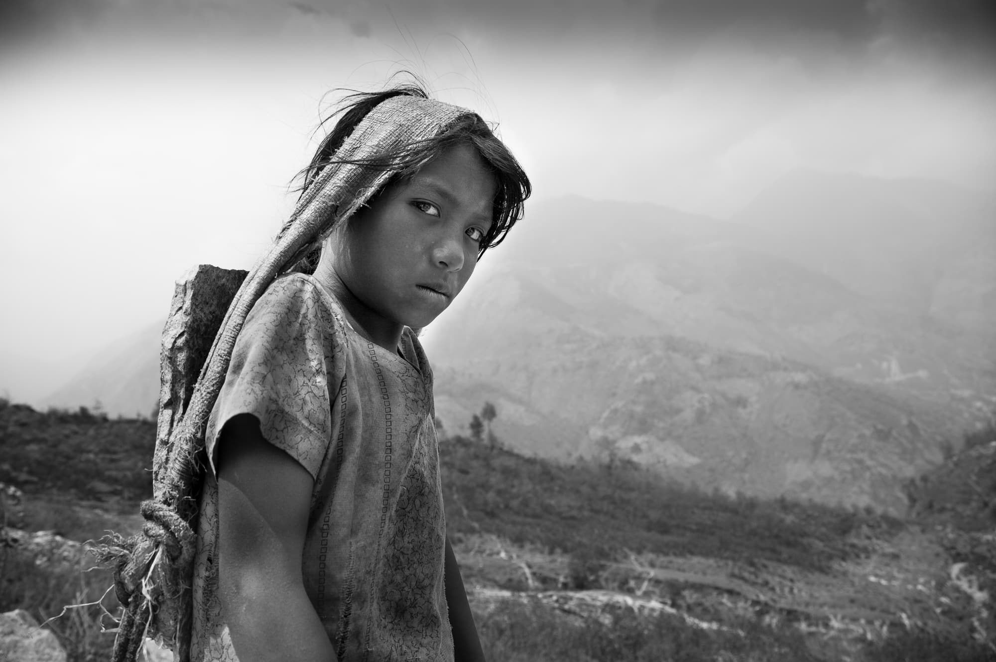 Girl with stones on her back in Nepal