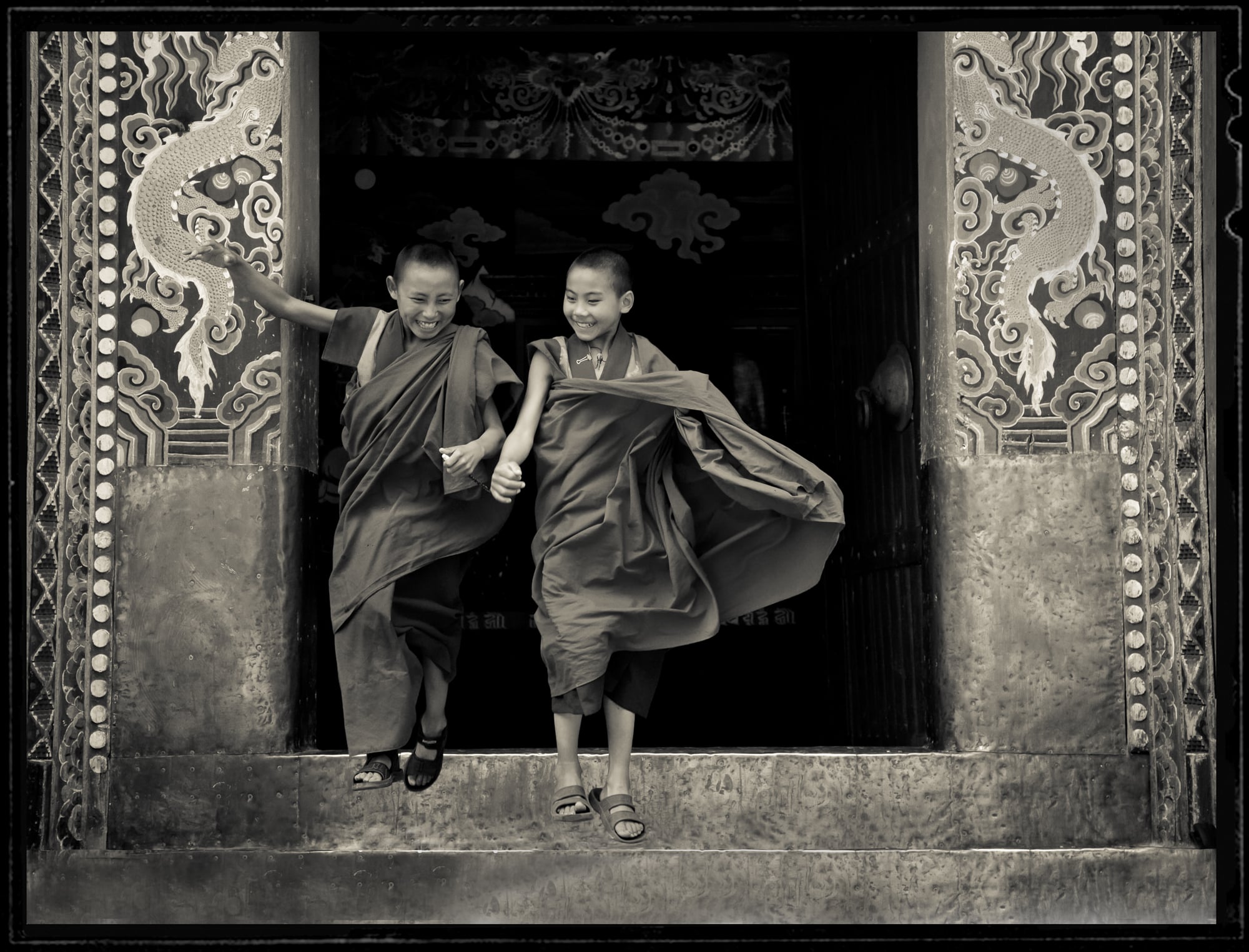 Two girls jumping down stairs in Bhutan