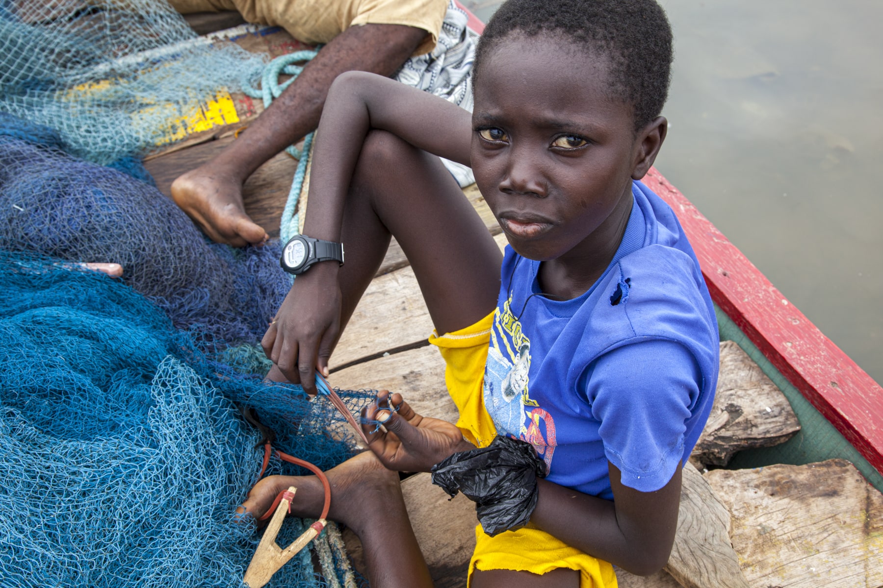 Boy mending nets in Ghana