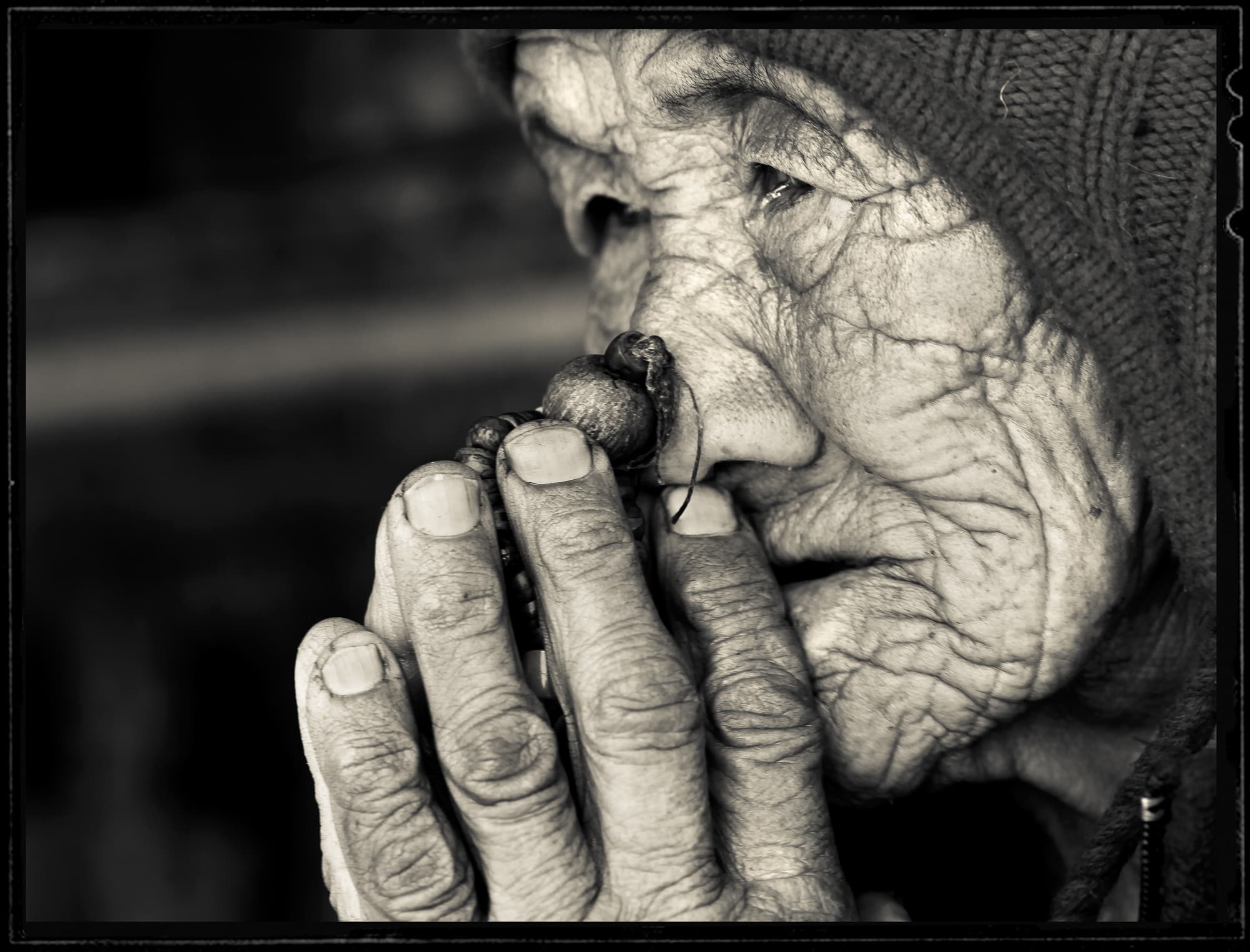 Old women holding prayer beads in Bhutan
