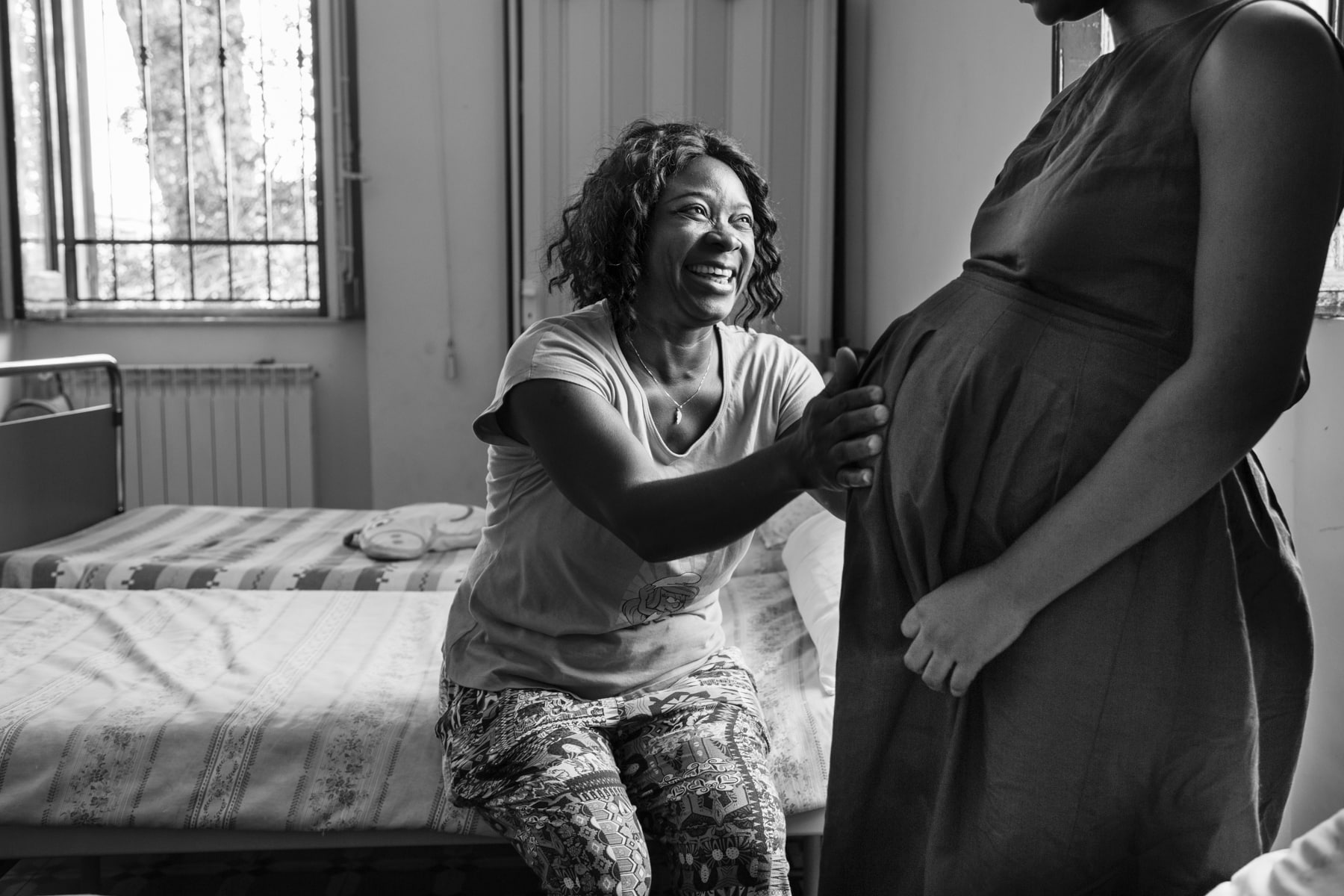 Women touches the belly of a pregnant minor sex slave