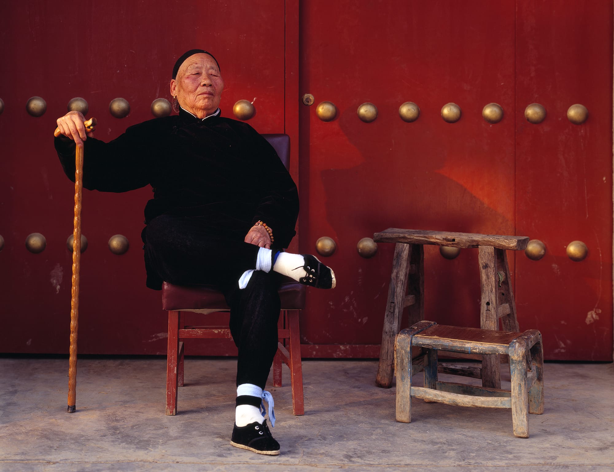 Man sitting on a red chair in front of a red door